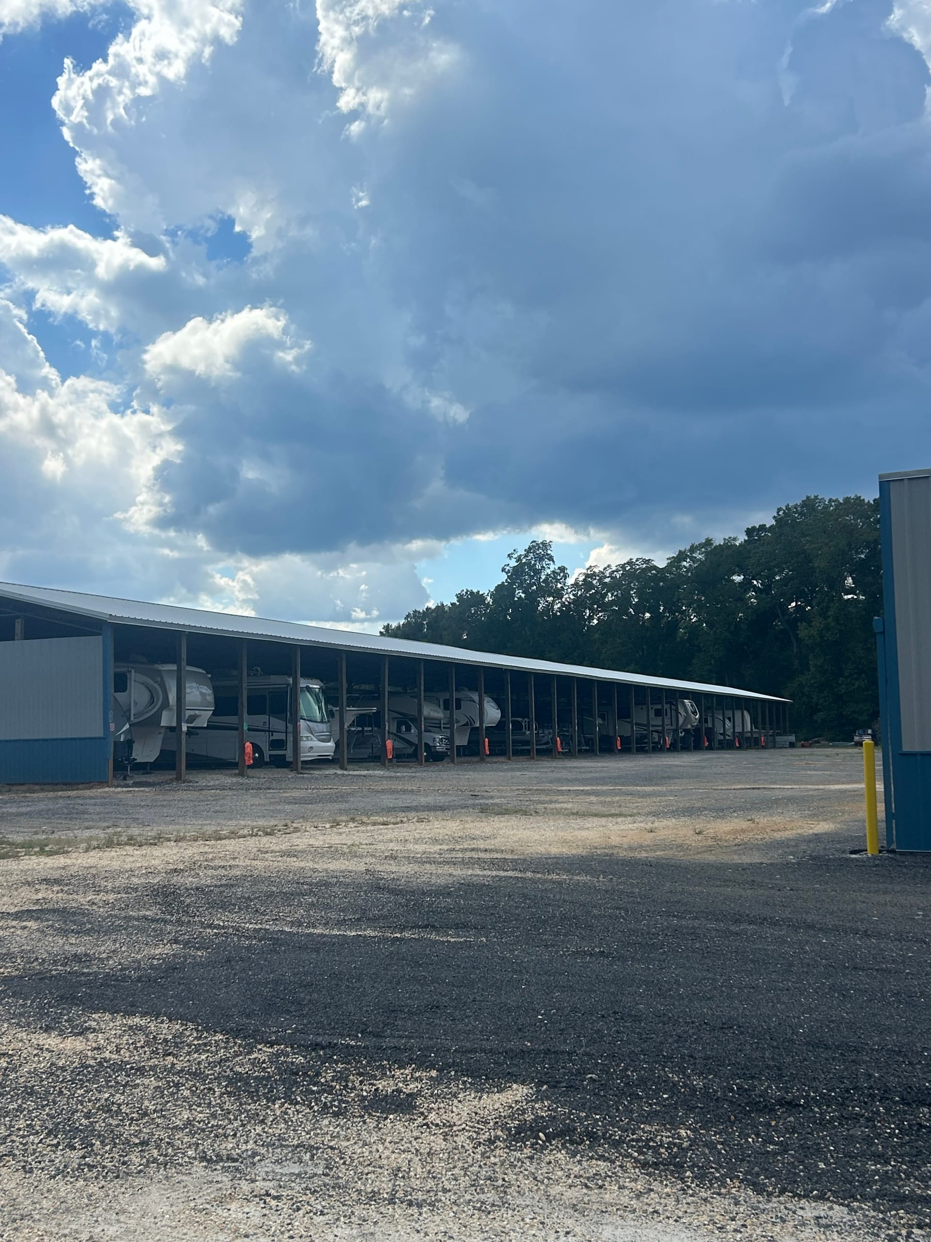 Long covered parking structure with RVs and campers parked underneath