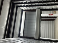Open storage unit roll-up door inside a covered corridor at Safe Storage Solutions